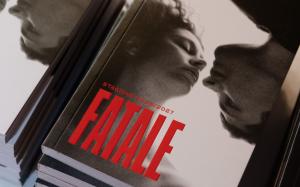 Stacks of brochures for the 2026/2027 Teatro Regio Season, featuring a cover with two black-and-white faces leaning in almost to the point of touching, topped by the word “Fatale” in large red letters.
