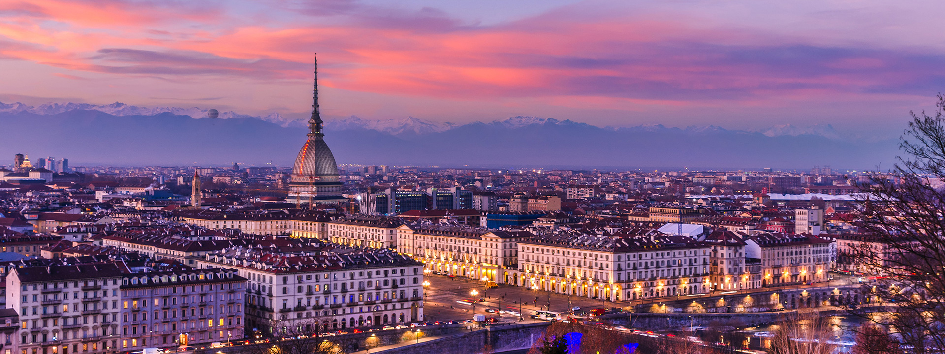 View of Turin at sunset beneath a pink sky